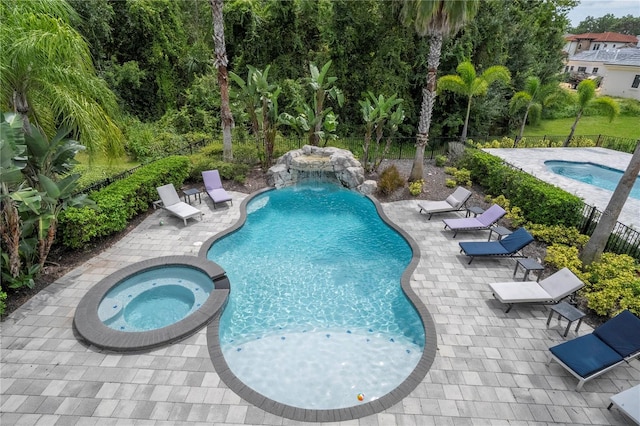 view of swimming pool featuring an in ground hot tub, a patio area, and pool water feature