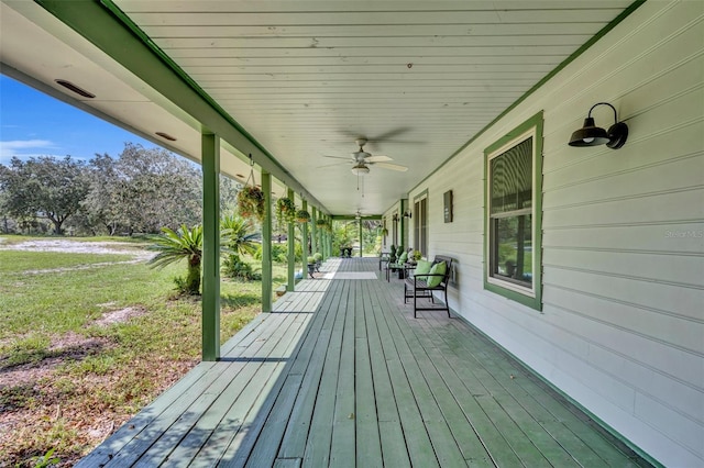 wooden deck featuring covered porch and ceiling fan