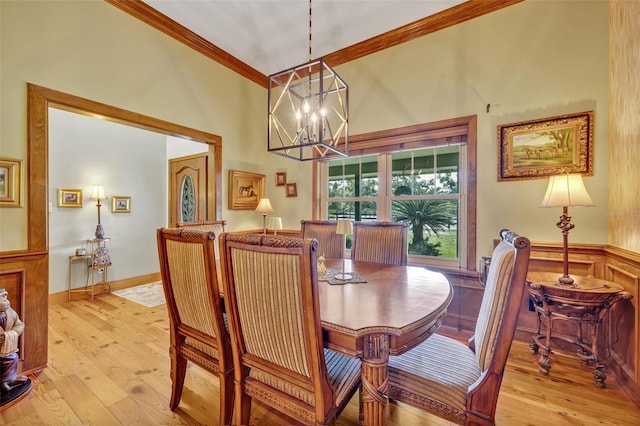 dining space with a chandelier, light wood-type flooring, and ornamental molding