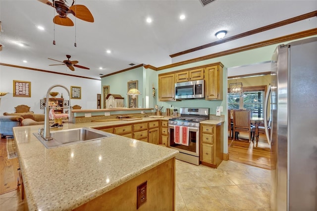 kitchen with ceiling fan, stainless steel appliances, ornamental molding, light stone counters, and sink