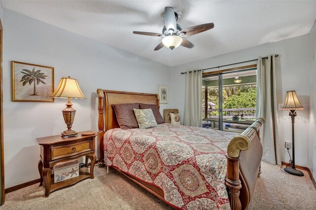 carpeted bedroom featuring ceiling fan, access to exterior, and a textured ceiling