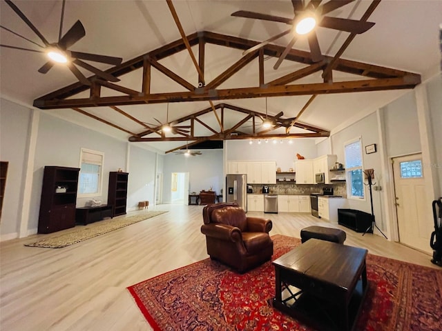 living room featuring high vaulted ceiling, light wood-type flooring, and beamed ceiling