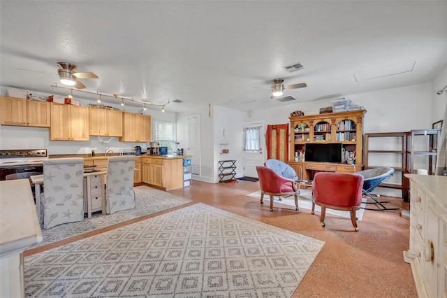 interior space featuring ceiling fan, light brown cabinetry, and electric range oven