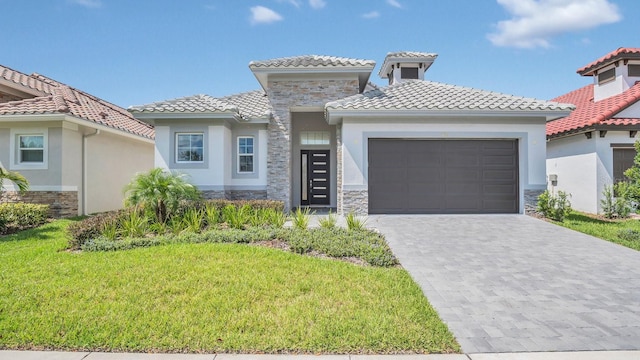 mediterranean / spanish home featuring a garage and a front lawn