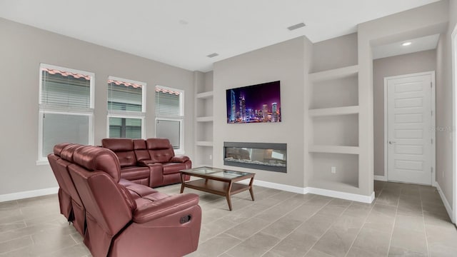 living room with built in features and light tile patterned floors