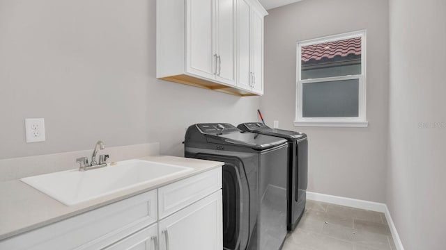 laundry area featuring cabinets, light tile patterned floors, washer and clothes dryer, and sink