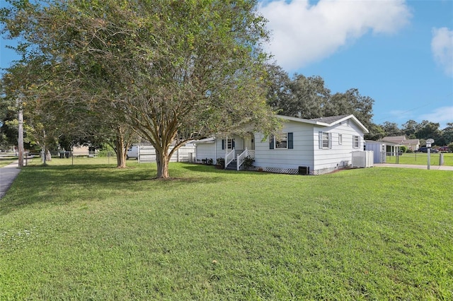 view of property exterior with a lawn and central AC