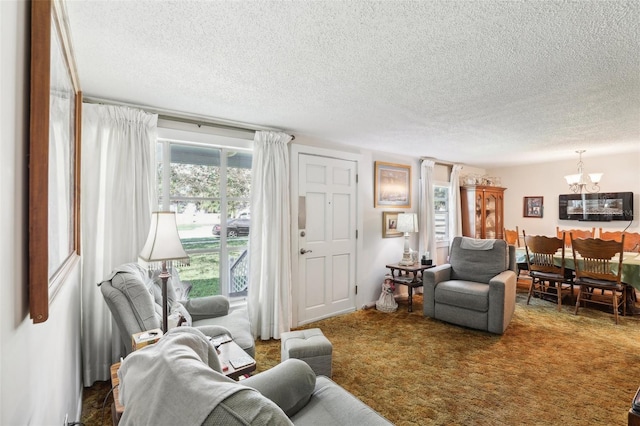 carpeted living room featuring a textured ceiling and an inviting chandelier