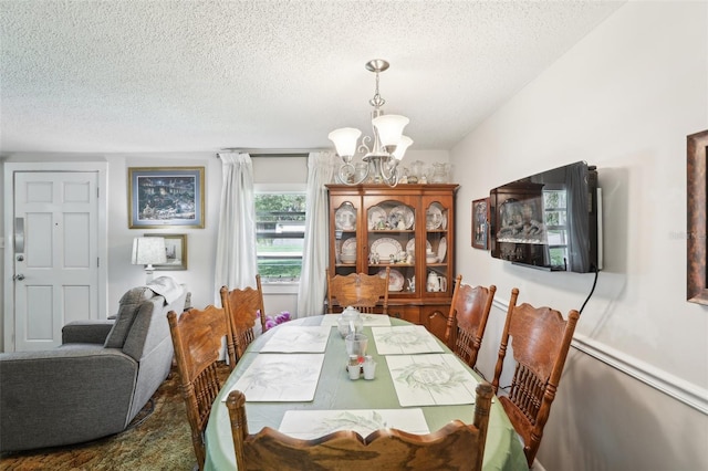 dining area featuring a notable chandelier and a textured ceiling