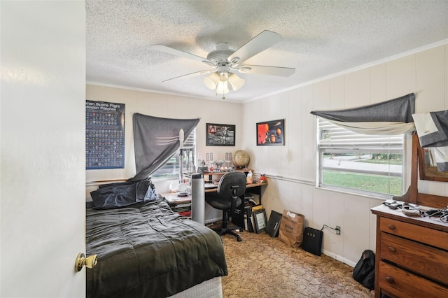 bedroom featuring carpet floors, wood walls, a textured ceiling, crown molding, and ceiling fan