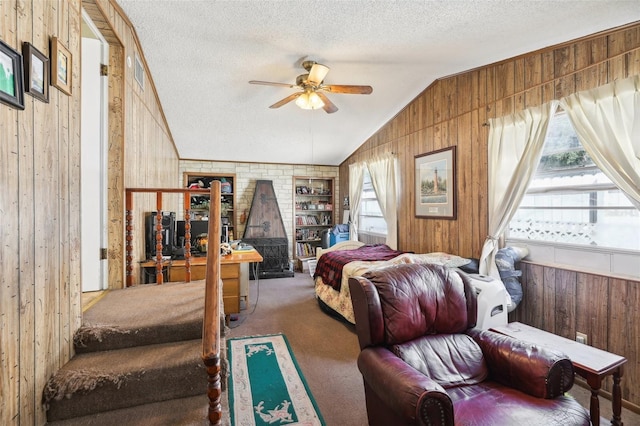 carpeted bedroom featuring wooden walls, vaulted ceiling, ceiling fan, and a textured ceiling