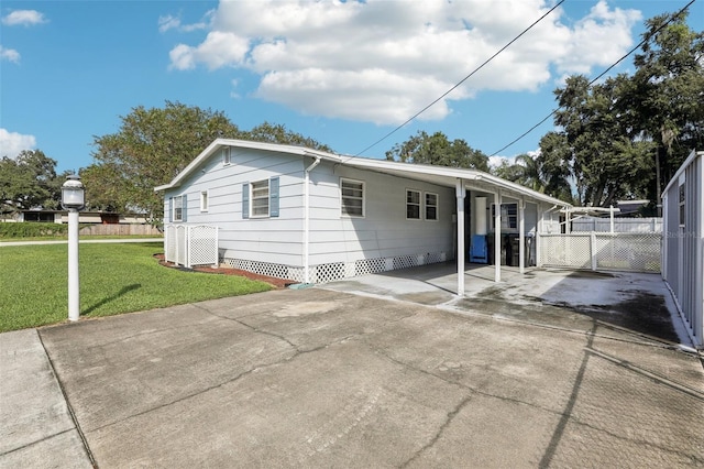 back of property featuring a lawn and a carport