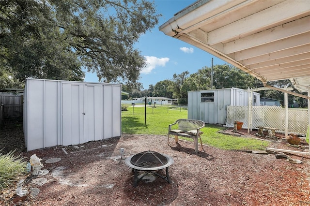 view of yard with a storage shed and an outdoor fire pit