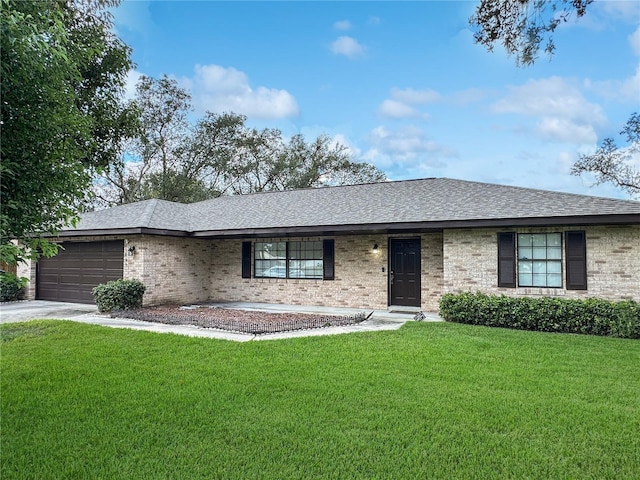 ranch-style house featuring a garage and a front lawn