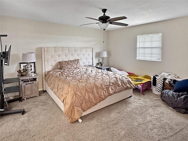 bedroom with ceiling fan, carpet flooring, and a textured ceiling