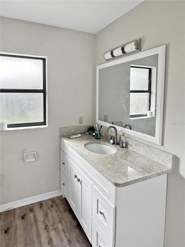 bathroom with hardwood / wood-style flooring, plenty of natural light, and vanity