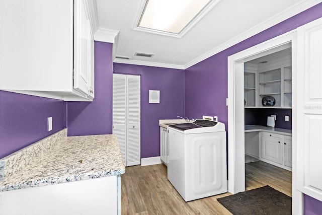 washroom with washer / clothes dryer, cabinets, ornamental molding, and light hardwood / wood-style flooring