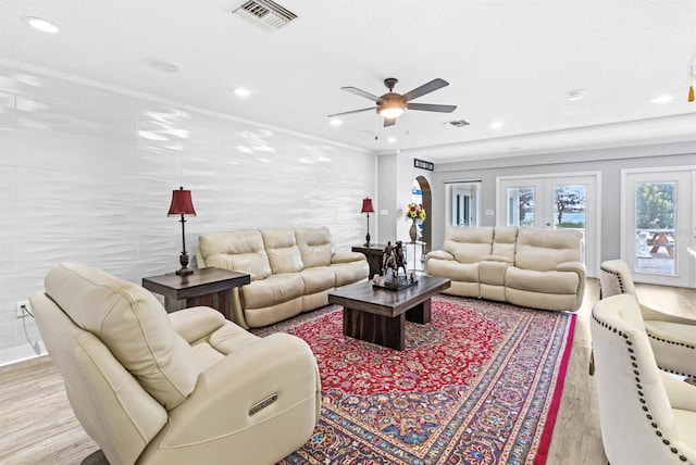 living room with light hardwood / wood-style floors, ceiling fan, a textured ceiling, and ornamental molding