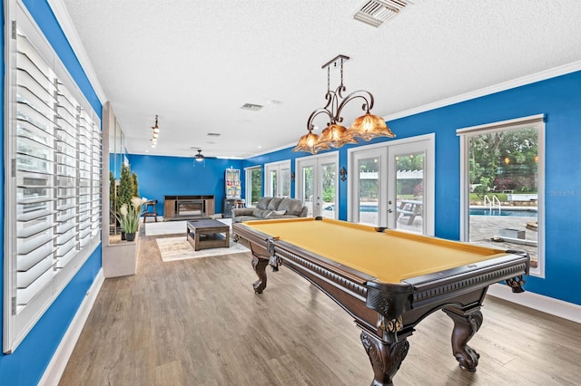 game room with a textured ceiling, french doors, and hardwood / wood-style flooring