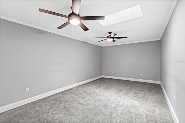 spare room featuring a skylight, carpet flooring, ceiling fan, and crown molding