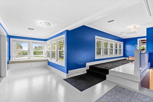 interior space featuring a textured ceiling and crown molding