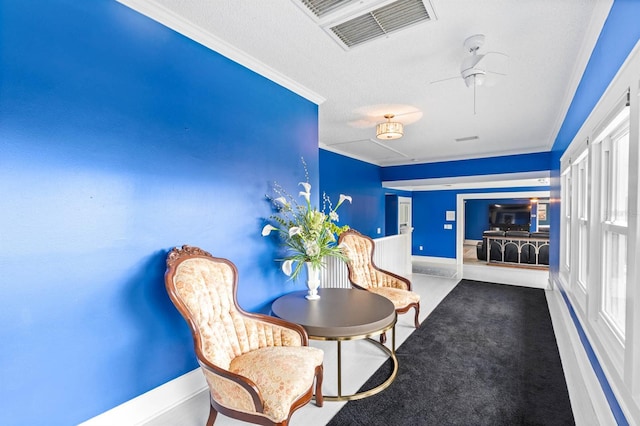 interior space with ornamental molding, carpet, a textured ceiling, and ceiling fan