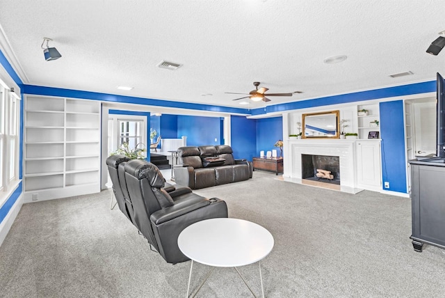 carpeted living room with a brick fireplace, ceiling fan, and a textured ceiling