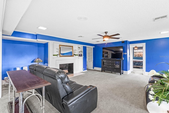 carpeted living room with a fireplace, ceiling fan, and a textured ceiling