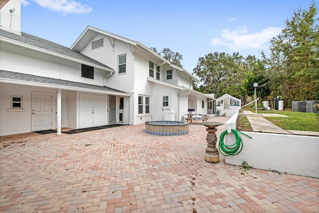 exterior space featuring central air condition unit, a patio, and a jacuzzi