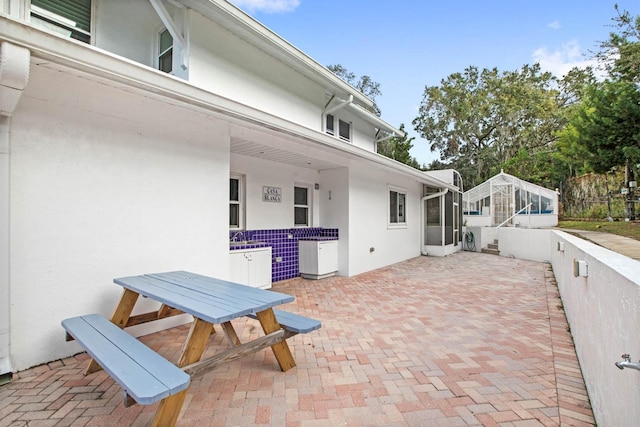 view of patio featuring a sunroom