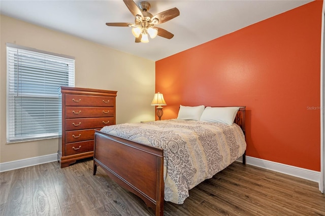 bedroom with multiple windows, dark wood-type flooring, and ceiling fan