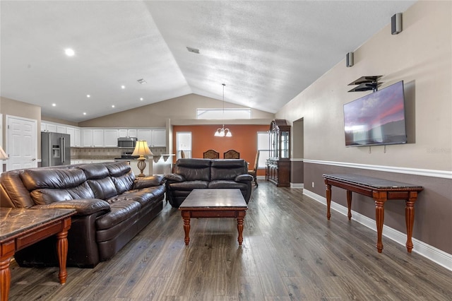 living room with lofted ceiling, dark hardwood / wood-style floors, and a notable chandelier