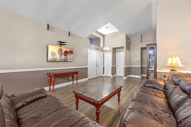 living room featuring hardwood / wood-style floors, vaulted ceiling, and ceiling fan