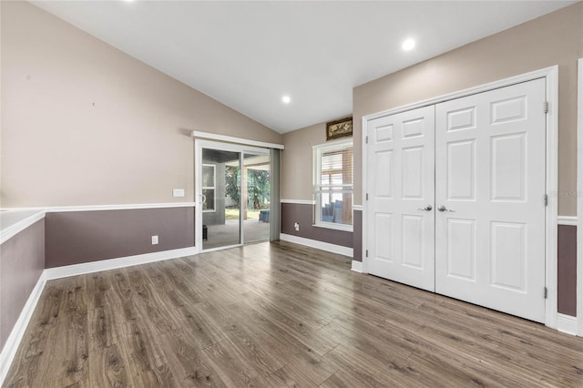 interior space featuring hardwood / wood-style flooring, vaulted ceiling, and access to outside