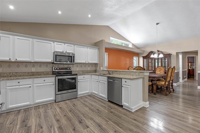 kitchen with tasteful backsplash, white cabinetry, appliances with stainless steel finishes, and kitchen peninsula