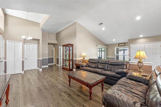 living room with wood-type flooring, a chandelier, and high vaulted ceiling