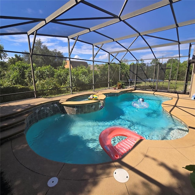 view of swimming pool featuring a patio, glass enclosure, an in ground hot tub, and pool water feature