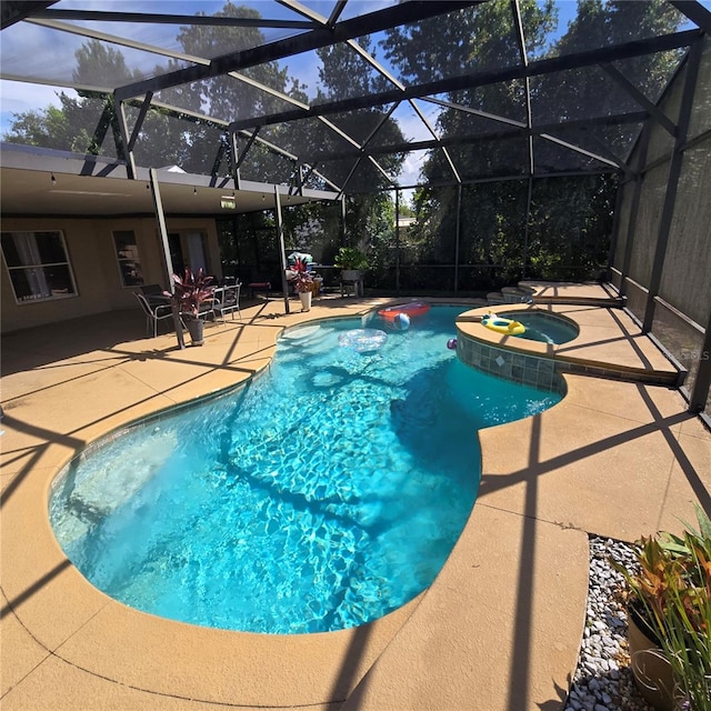 view of pool with a lanai, an in ground hot tub, and a patio area