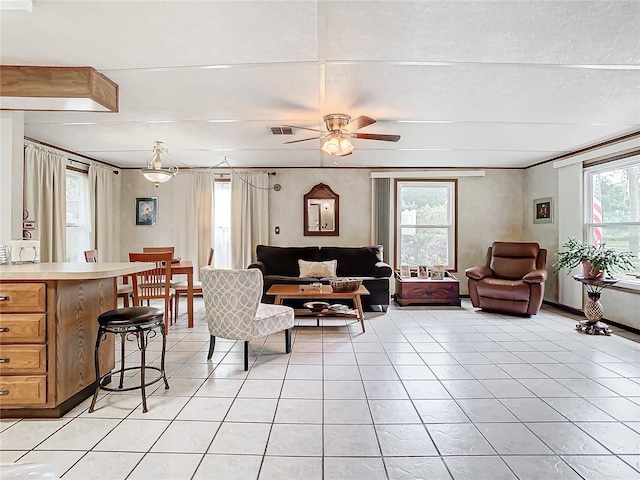 living room with ceiling fan, light tile patterned floors, and a healthy amount of sunlight