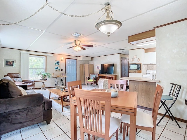 tiled dining room with an AC wall unit and ceiling fan