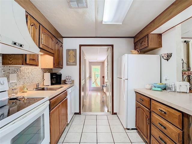 kitchen featuring light tile patterned floors, sink, white appliances, range hood, and decorative backsplash