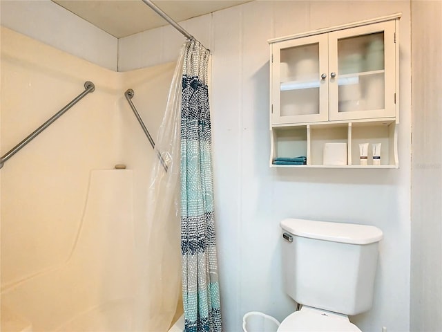 bathroom featuring walk in shower and toilet