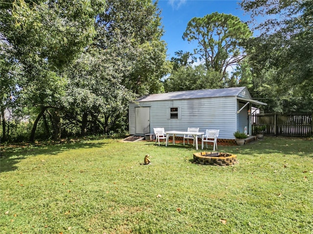 view of yard featuring an outbuilding and an outdoor fire pit