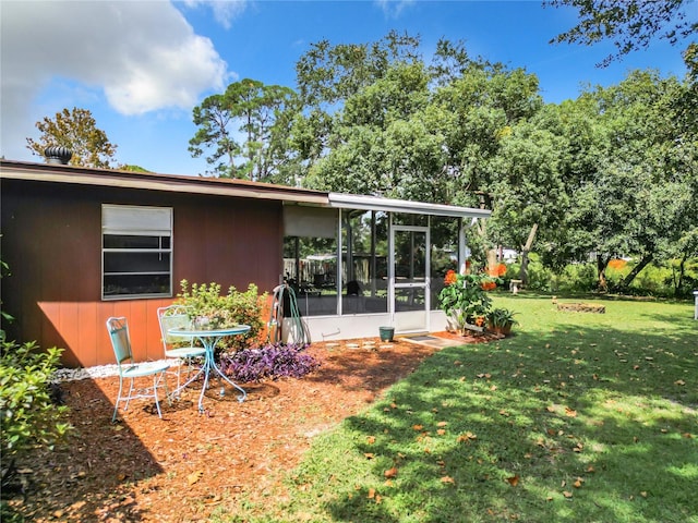 back of house with a lawn and a sunroom