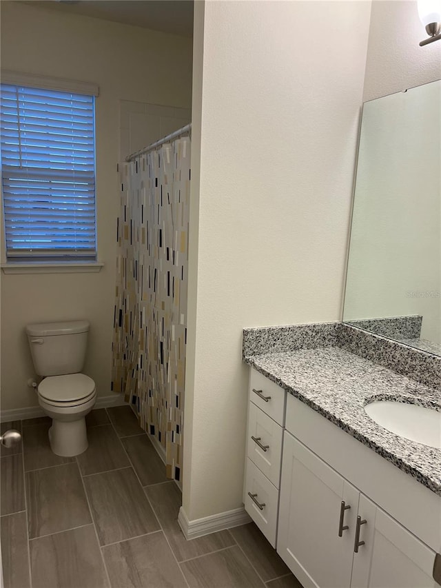 bathroom featuring curtained shower, toilet, and vanity