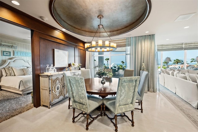 dining area with an inviting chandelier and a raised ceiling