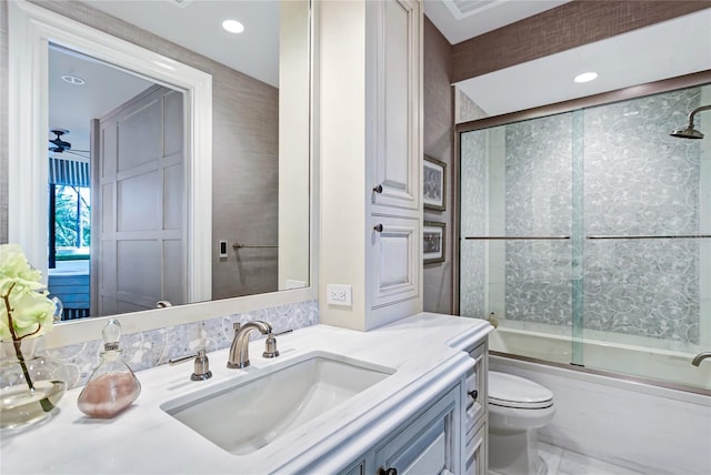 full bathroom with vanity, enclosed tub / shower combo, and toilet