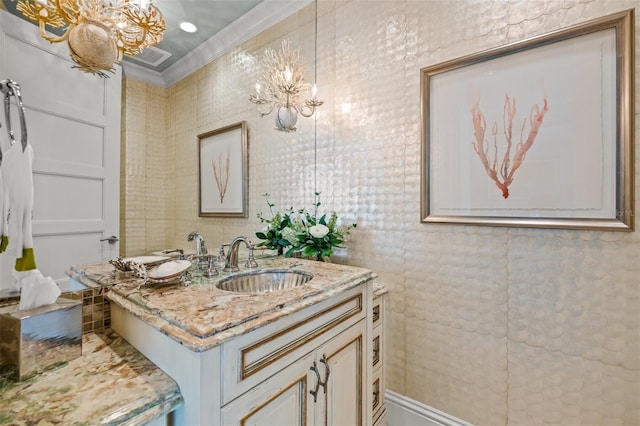 bathroom with a notable chandelier, vanity, and crown molding