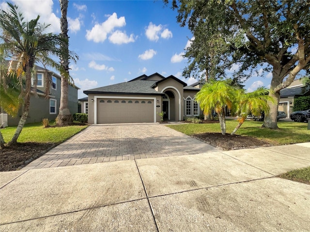 ranch-style home featuring a front lawn and a garage