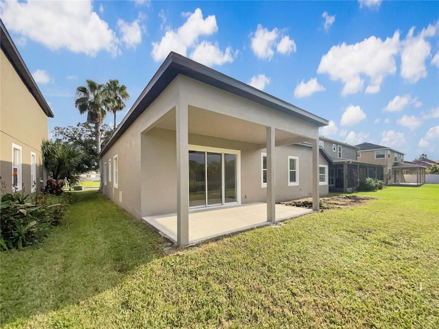 back of property with a yard and a patio area